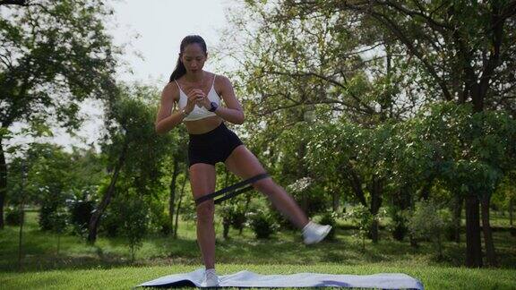 亚洲妇女使用阻力带设备进行腿部锻炼