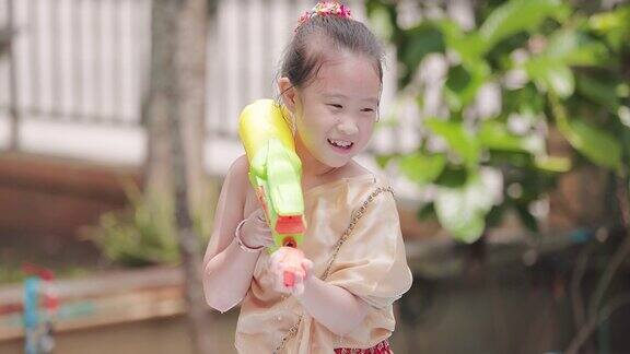 穿着泰国传统服装的孩子们在泼水节玩水枪