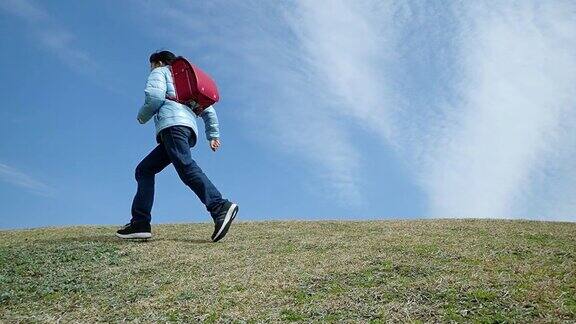 日本一名小学生在蓝天上奔跑