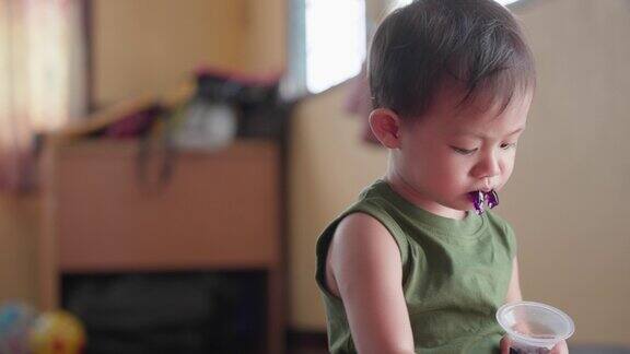 亚洲小男孩吃着甜甜的水果果冻明胶甜点