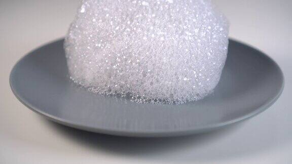 洗涤剂泡沫滴在灰色的陶瓷盘子上