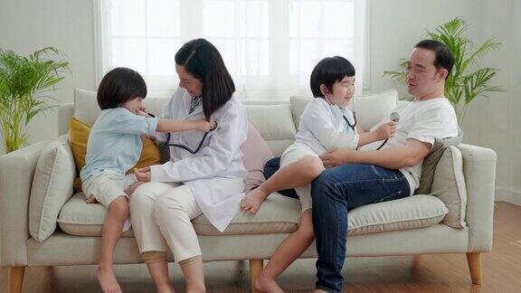 亚洲家庭关系父亲母亲和儿子玩医生和病人在他们的家里