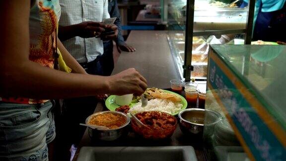印度街头小吃塔利女人把酱汁放在盘子里