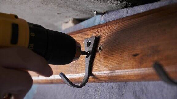工匠用电动螺丝刀将自攻螺钉拧入单板