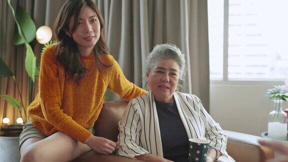幸福亚洲家庭坦诚的女儿和儿子拥抱祖父母妈妈年长的妈妈舒适放松在沙发沙发惊喜访问在家里的客厅一起拥抱快乐的亚洲家庭在家里