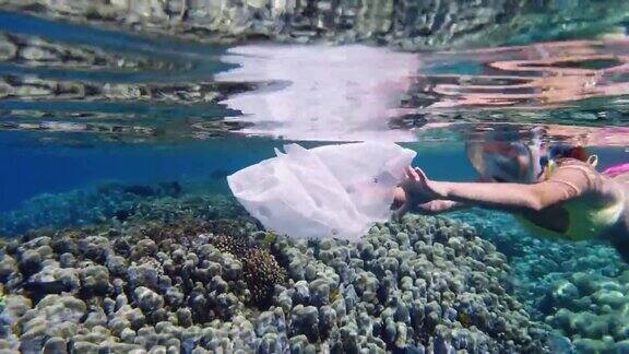 海里的垃圾在海上收集垃圾志愿者少女戴着潜水面罩收集漂浮的垃圾漂浮的塑料袋海洋海洋污染环境保护