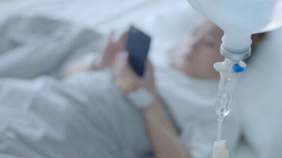 SLOMO女性患者边用智能手机边用生理盐水跟踪拍摄