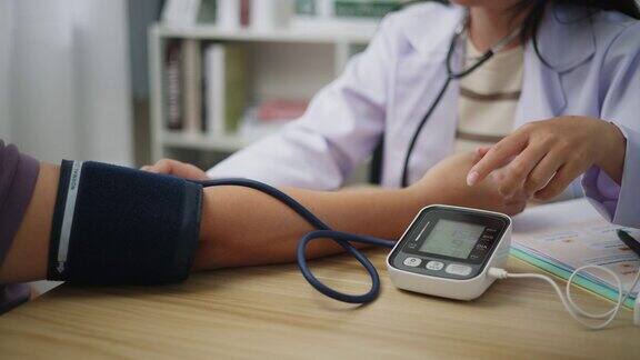 女医生在医院用带听诊器的血压计检查病人的血压
