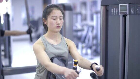 年轻的亚洲女性在健身房锻炼