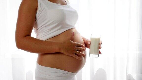 孕妇举起牛奶杯翘起大拇指表示健康营养