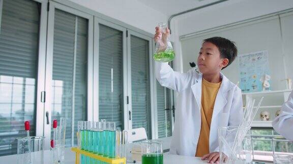 小男孩在烧杯中混合化学物质学校的STEM教育