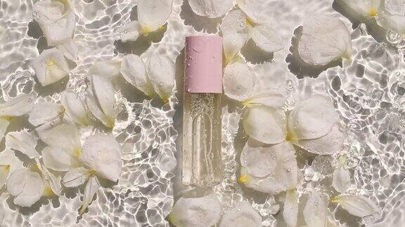 玫瑰花瓣在水面上以水滴的形式绽放化妆品瓶油液胶原蛋白血清瓶女性化妆品、护肤品布局美容产品样品