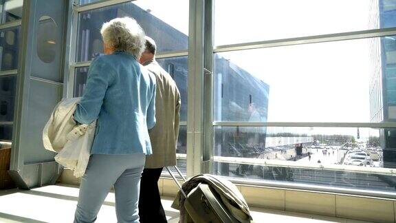 两个老人提着行李箱走路