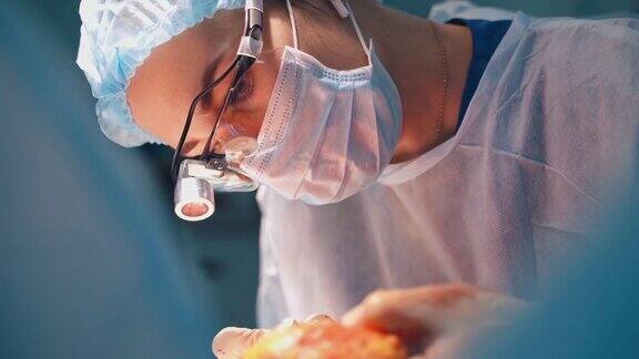 一个戴着外科口罩的女医生的肖像专业医生在做整形手术时向下看特写镜头