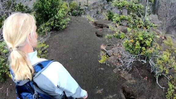 POV的女人走到火山岩石上背着背包
