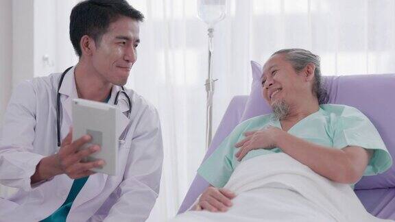 病房:一位和蔼的男医生正在和一位正在床上休息的老年病人交谈手术成功后