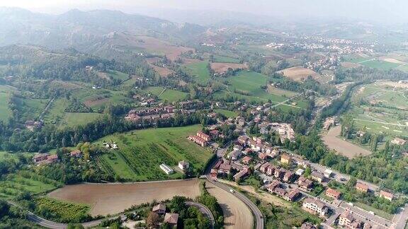 一个在绿色山丘之间山谷中的小镇从上面看从空中看全景欧洲意大利