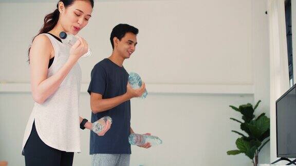 亚洲年轻夫妇一起锻炼的家庭背景居家隔离预防冠状病毒和新冠病毒感染的运动概念4k慢动作