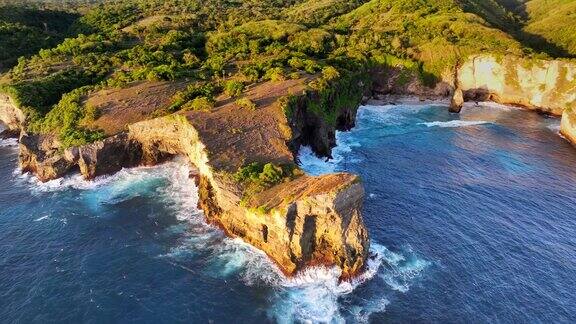 破碎海滩的移动海浪日落场景是巴厘岛努沙佩尼达岛最著名的观光景点之一这是岩石中形成的一个神奇的马蹄形圆形海湾