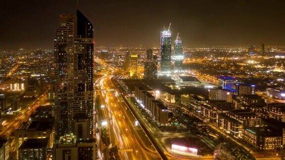 阿联酋迪拜高速公路枢纽的鸟瞰图日落时交通时间流逝迪拜市中心著名的谢赫·扎耶德路从屋顶观看交通和驾驶概念
