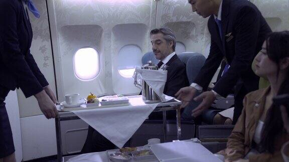 空中小姐在飞机上为乘客提供食物和饮料