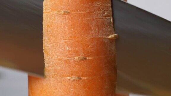 黑手套厨师用大刀削胡萝卜用刀切胡萝卜的微距镜头