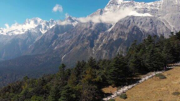 中国丽江的田野和玉龙雪山景观的4k鸟瞰图和移动前进