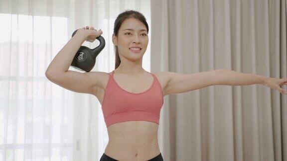 亚洲妇女做家庭运动与Kittle球健身概念保健