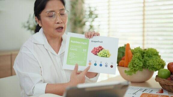 一名亚洲成年妇女正在网上向观众介绍蔬菜和水果的营养