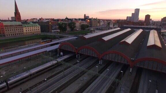 列车到达Malm?中央车站的鸟瞰图无人机拍摄日落时的铁路和城市景观背景是办公大楼瑞典