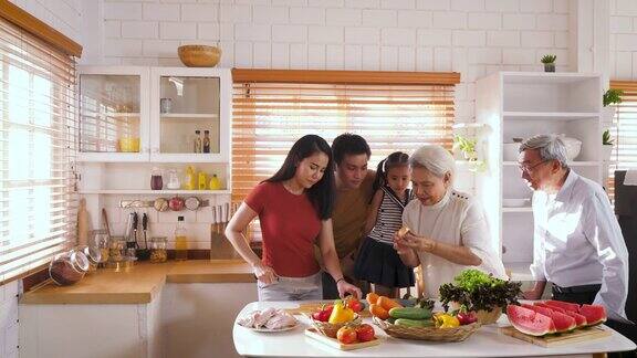 快乐的亚洲大家庭准备烹饪健康的食物在厨房家庭放松和花时间在一起在家里