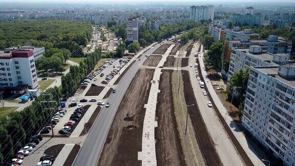 镜头低空飞过有电车线路、步行街的现代路口附近有现代化的房屋