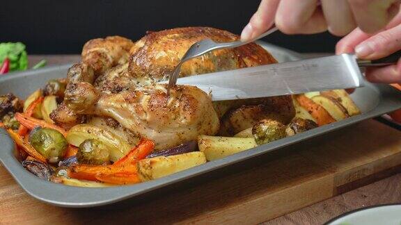 用刀叉切整只有机烤鸡的特写镜头提供玉米饲料烤鸡切片和分割鸡肉蔬菜和鸡肉在4K的桌子上