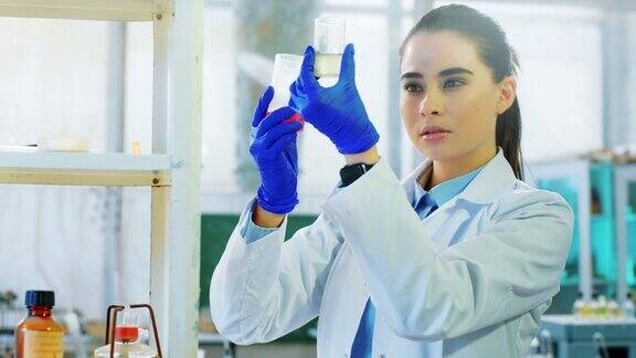 生物化学和药学概念女科学家在实验室里把一些化学液体溶液混合在玻璃浴盆里非常浓缩由ARRIAlexaMini拍摄