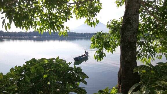 面目全非的湖上船夫操纵着他的木排船渡过湖面树遮住了视野模糊了