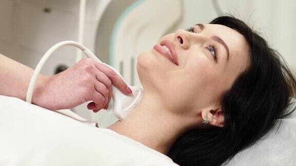 一位年轻女性甲状腺的超声诊断一名女医生拿着超声波探头沿着病人的脖子健康