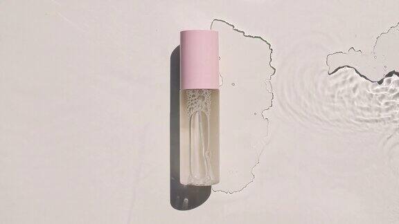 一款保湿护肤品的广告化妆品瓶小瓶在水面上滴药水水反射阳光和阴影缓慢运动的波浪水