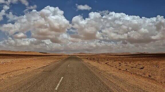 阴天行驶在荒凉偏远的突尼斯沙漠公路上汽车司机的视角