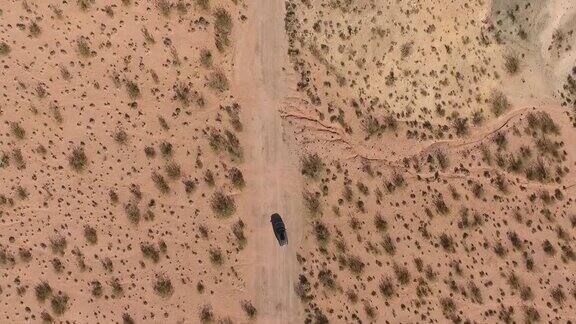 在犹他州纪念碑谷的长公路上飞行-无人机在亚利桑那州汽车上空飞行俯视图无人机镜头飞过干燥和米色沙漠干旱导致景观全球变暖威胁