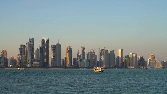 卡塔尔多哈的传统的卡塔尔独桅帆船在摩天大楼前航行