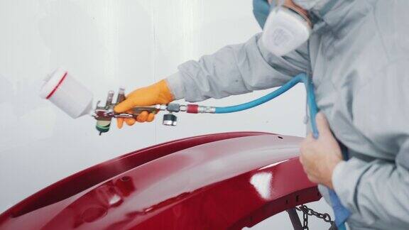 汽车喷漆工在专用展台车门上喷红漆在汽车维修车间喷漆车辆零件汽车制造厂汽车涂料服务优质汽车车身店理念