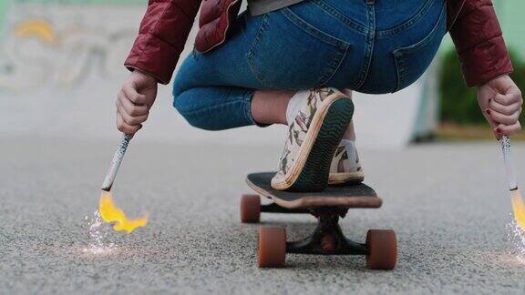 十几岁的女孩骑着滑板手里拿着火棒