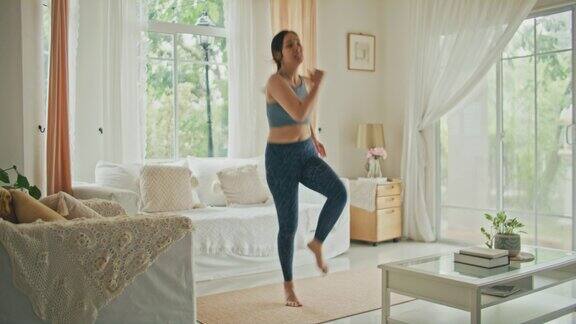 穿着休闲服装的健身女士在客厅做运动