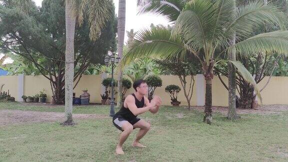 由于COVID-19大流行的隔离运动成熟男子在家花园里训练跳蹲