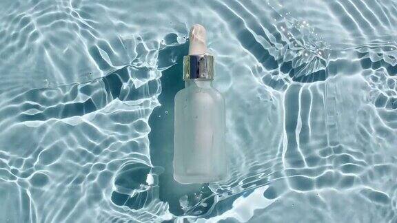 美容spa瓶为血清胶束爽肤水和乳液在水纹理背景与飞溅医学皮肤护理包装设计的视频化妆品的广告
