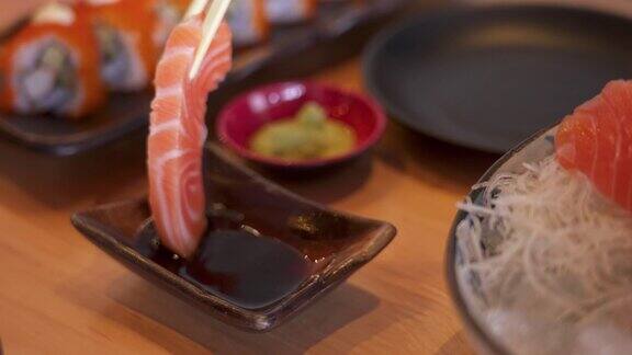 SLOMO筷子将芥末放在三文鱼刺身上浸在烧鱼里