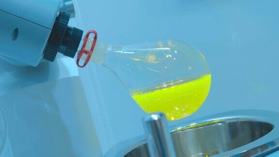 实验室的电动混合器在玻璃烧瓶中混合一种黄色溶液