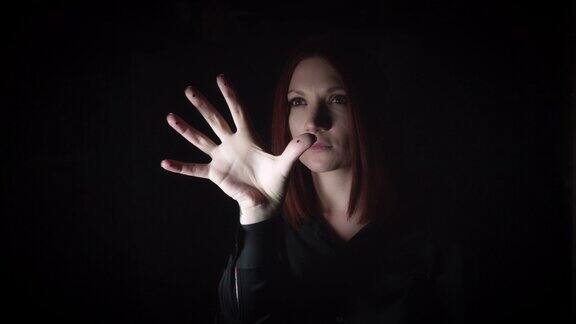 一个女人用手在看不见的按钮上做手势的4K肖像