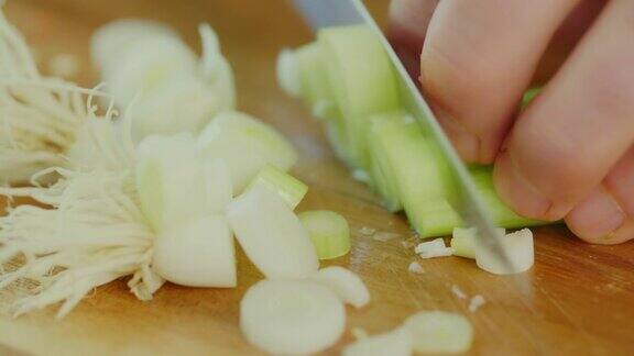 男子在切菜板上切葱的特写