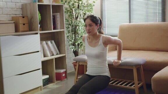 亚洲女性在家里的沙发上锻炼